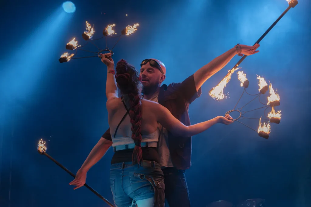 Zwei Künstler von Elements of Fire mit brennenden Feuerfächern auf der Wacken-Bühne.