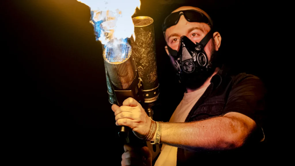 Künstler mit Endzeit-Maske und Hand-Flammenwerfer beim Wacken Open Air.